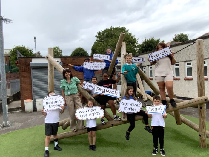 IMG-3026 children are standing on and around a climbing frame holding signs with messages relating to rights